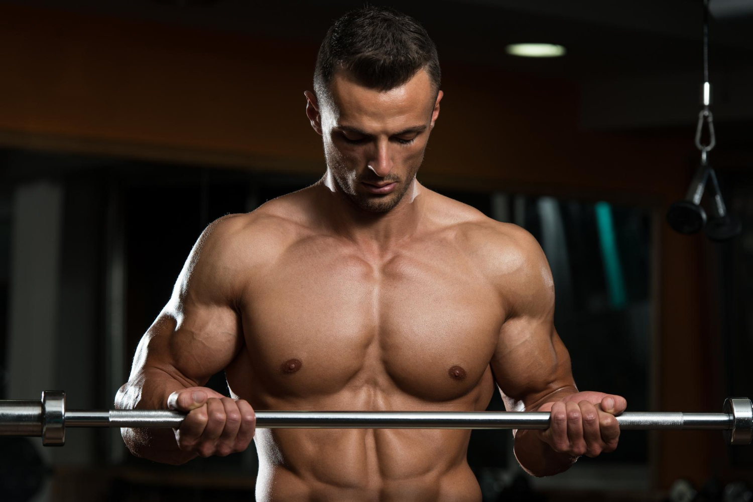 Muscle Retention Muscular man doing heavy weight exercise for biceps