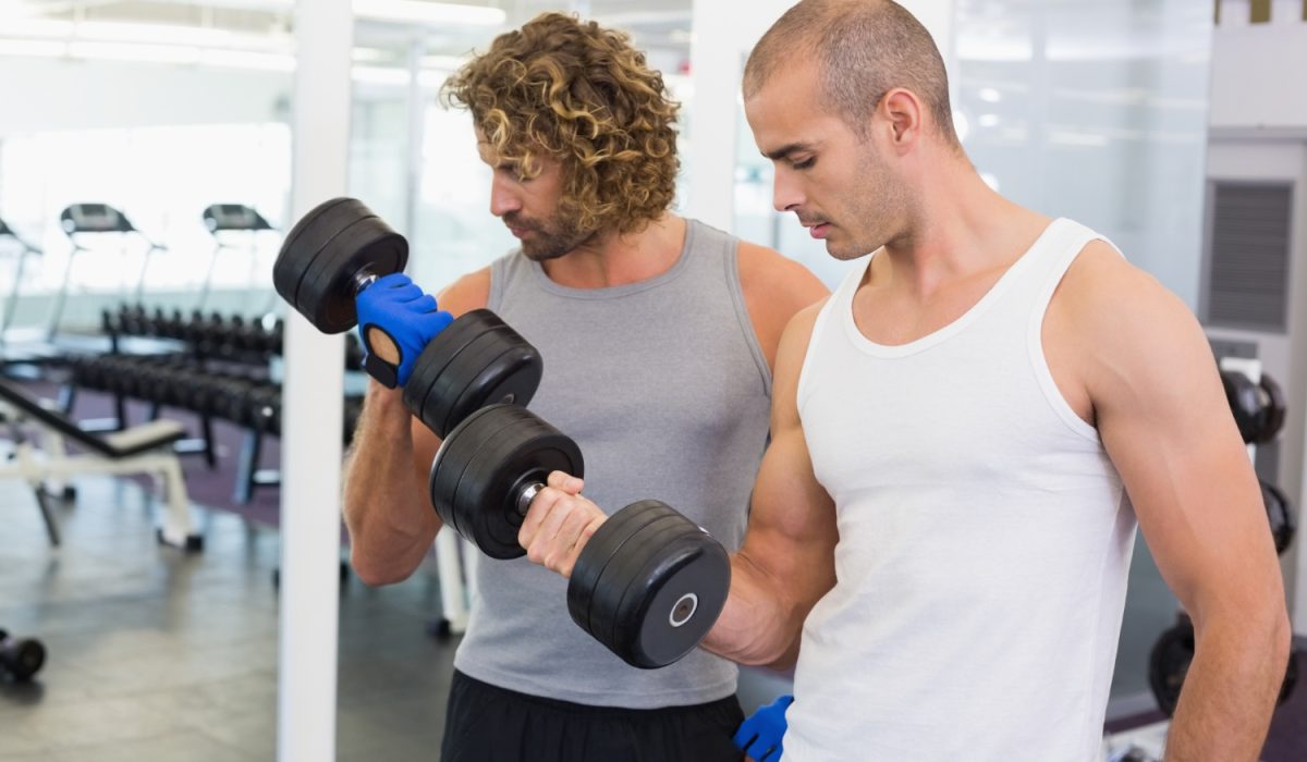 Sporty men exercising with dumbbells in gym