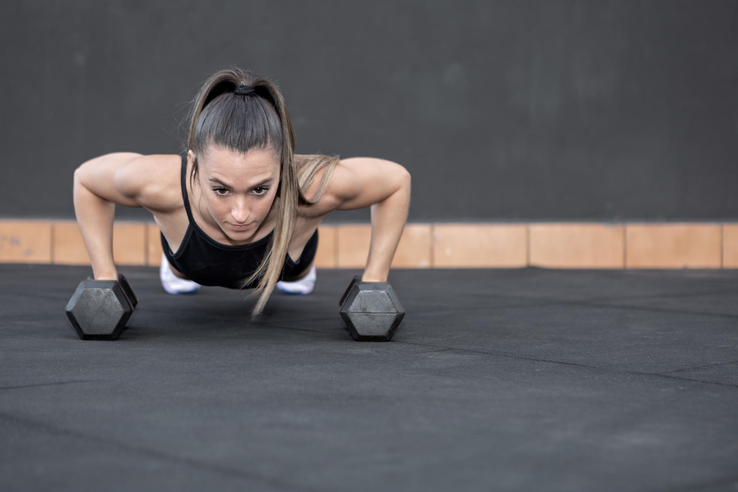 Creatine-for-women-lifting Sportswoman doing push ups on dumbbells